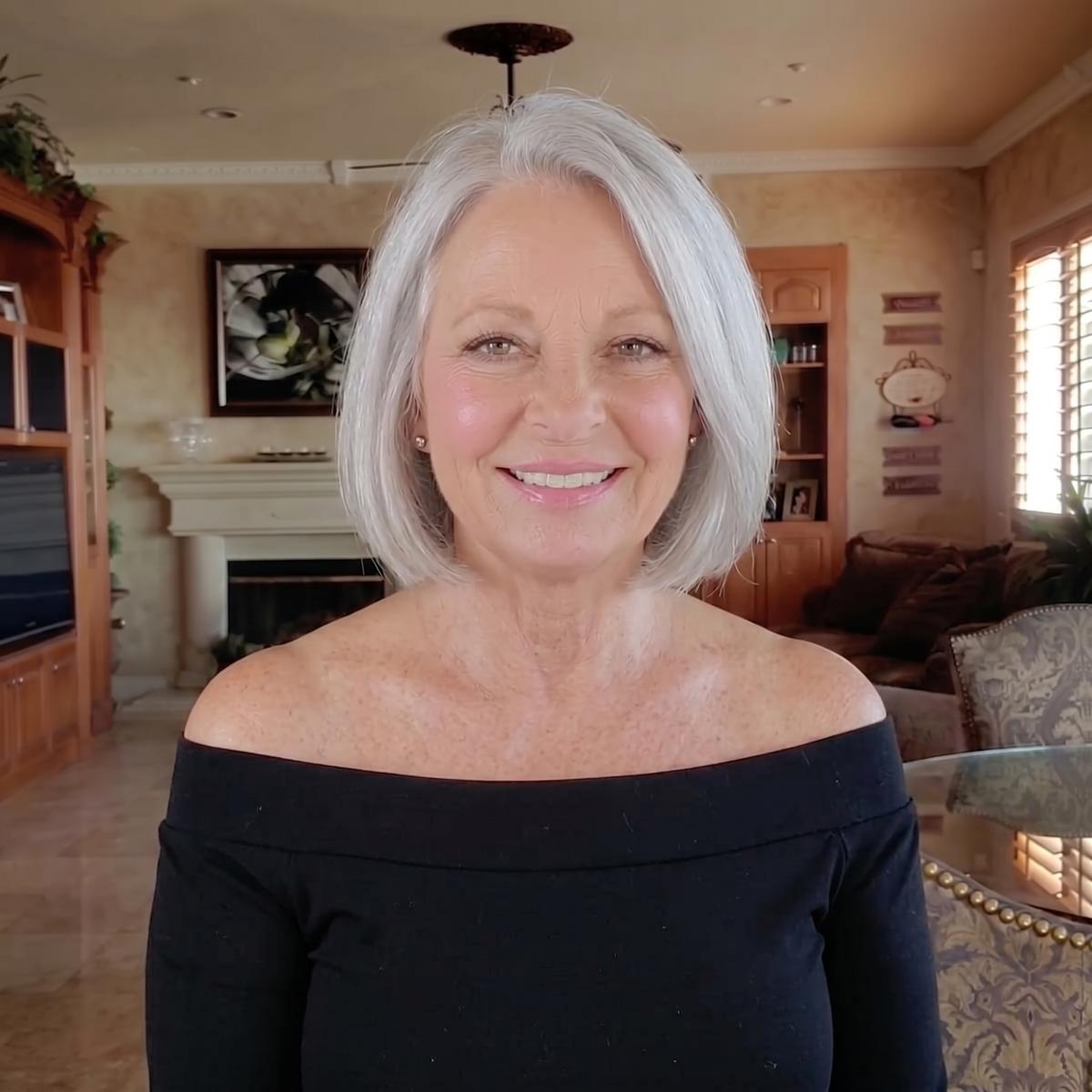 A confident woman in her early sixties smiling with bare arms